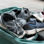 Où jeter vos chaussures usagées ? Collecte, don et réemploi Chaussures abimees empilees dans un bac de recyclage